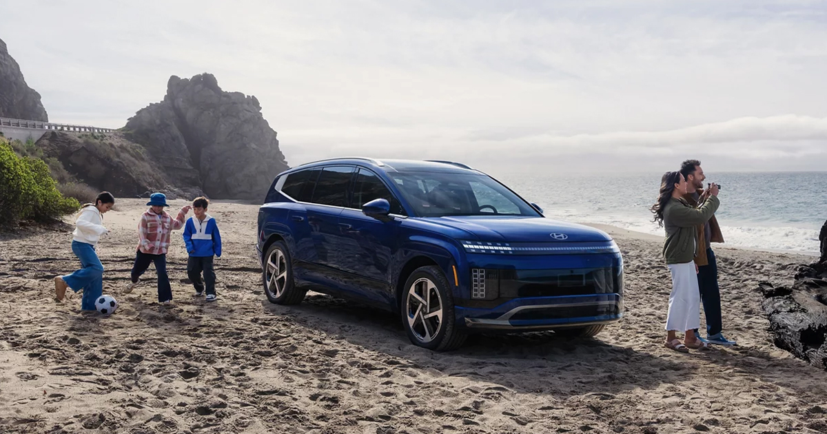 A family with their Hyundai on the beach.