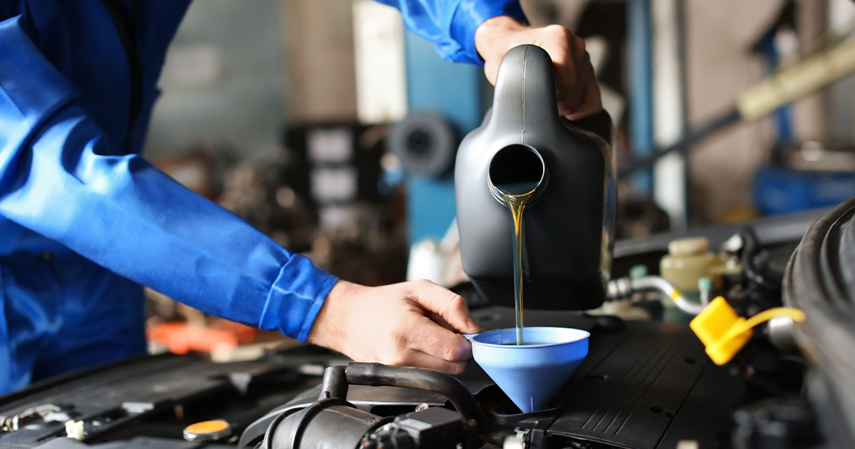 Close-up of a service technician performing an oil change on a vehicle in the service center.
