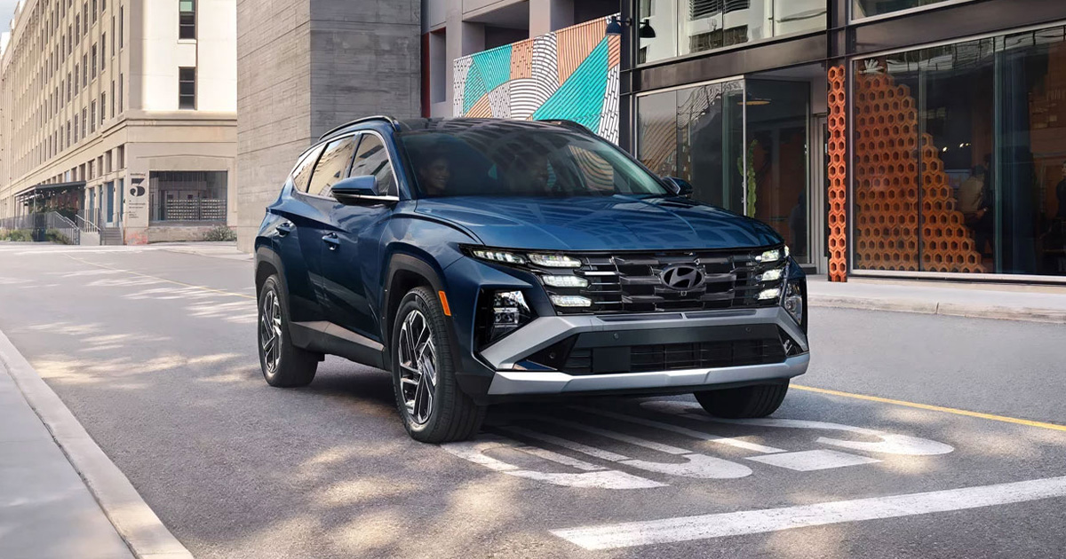 A Hyundai Tucson at a stop sign in a city.